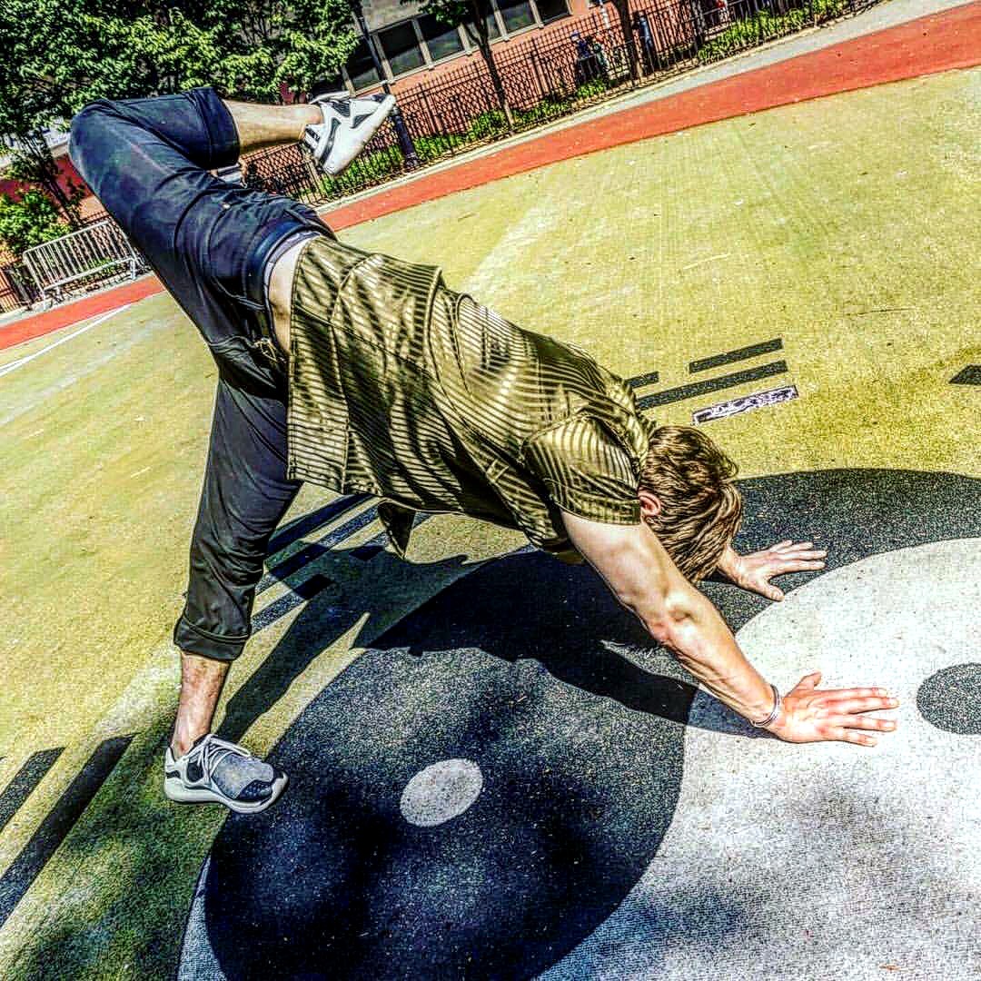 Kiefer Wiedmaier holding an animal flow position on an outdoor court