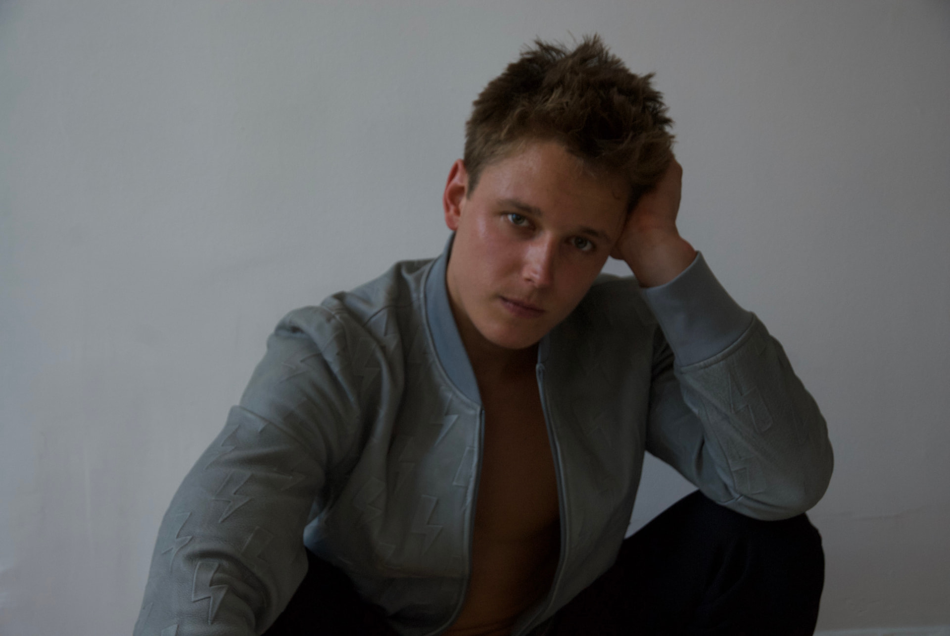 Editorial portrait of Kiefer Wiedmaier seated against a plain wall